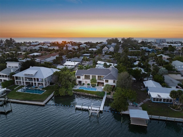 aerial view at dusk with a residential view and a water view