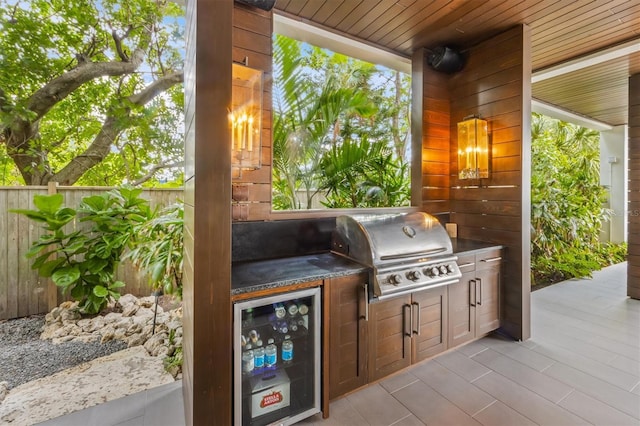 view of patio featuring wine cooler, grilling area, area for grilling, and fence