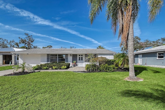 ranch-style house featuring an attached garage, concrete driveway, and a front yard