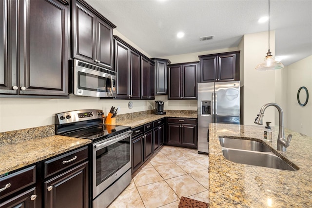 kitchen with light stone countertops, visible vents, stainless steel appliances, and a sink