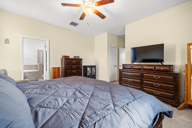 bedroom with ensuite bathroom, carpet floors, visible vents, and a ceiling fan