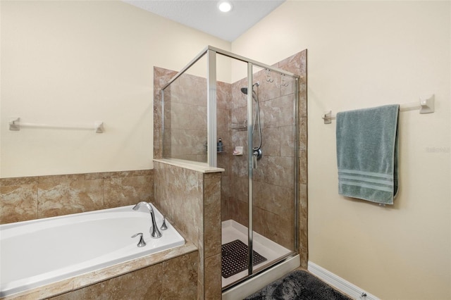 bathroom with a stall shower and a bath