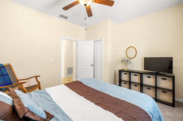 carpeted bedroom featuring a ceiling fan, visible vents, and baseboards