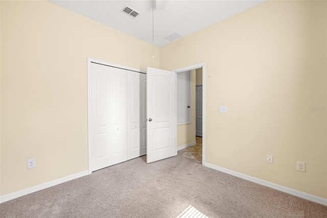 unfurnished bedroom featuring a closet, carpet flooring, visible vents, and baseboards