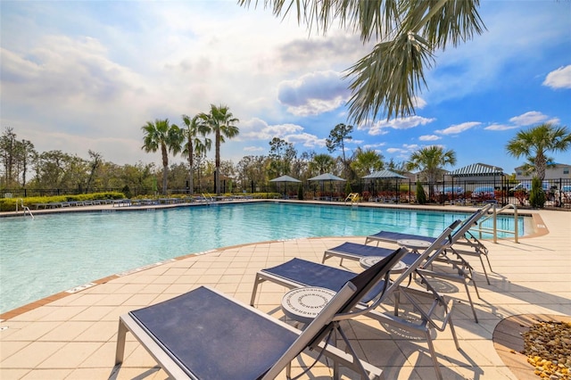 pool with a patio and fence