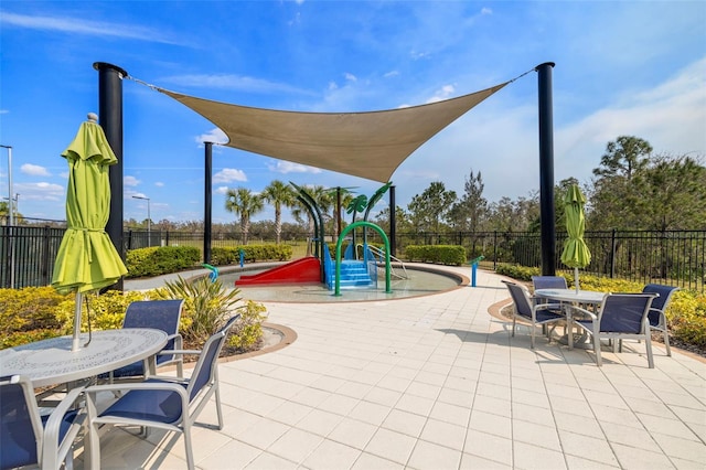 communal playground with outdoor dining area, fence, and a patio