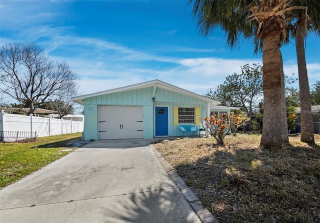 view of front of house featuring a garage, concrete driveway, and fence