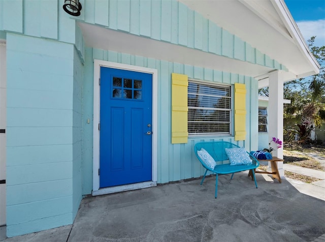 property entrance featuring a patio and board and batten siding