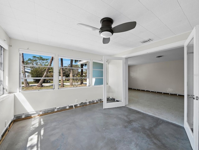 unfurnished room with visible vents, concrete flooring, and ceiling fan