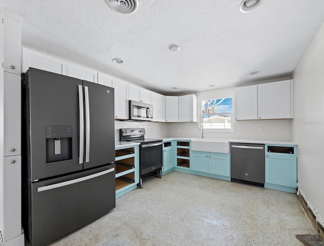 kitchen featuring a sink, a textured ceiling, visible vents, and stainless steel appliances