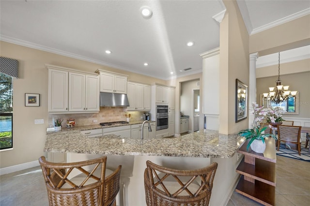 7108 Callander Cv, Lakewood Ranch, FL 34202 - kitchen featuring a breakfast bar, stainless steel appliances, decorative backsplash, ornamental molding, and under cabinet range hood