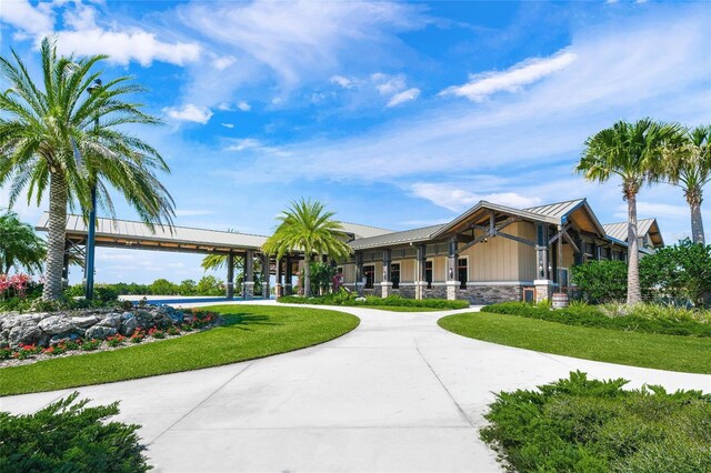 7108 Callander Cv, Lakewood Ranch, FL 34202 - exterior space with driveway, stone siding, metal roof, and a front yard