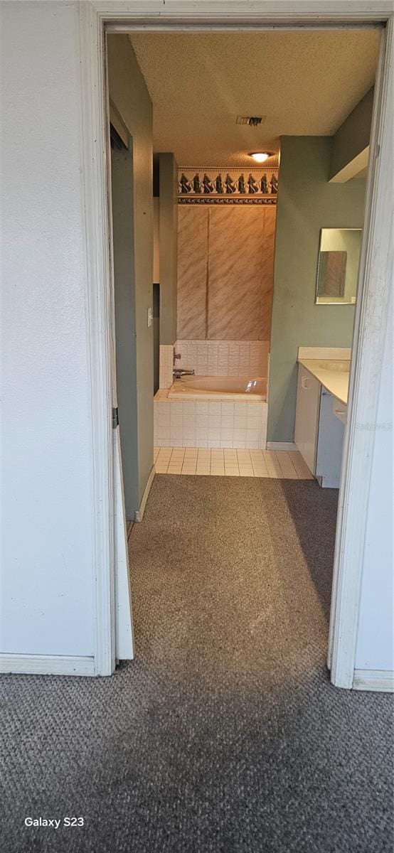 corridor featuring a textured ceiling and baseboards