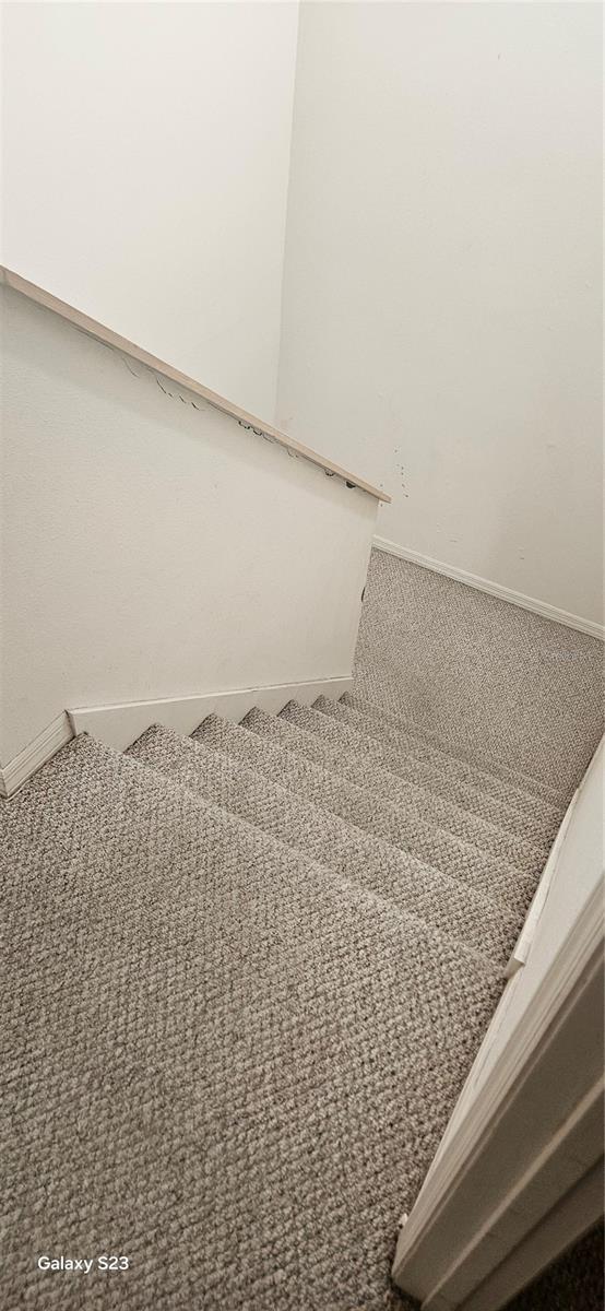 stairway with carpet floors and baseboards