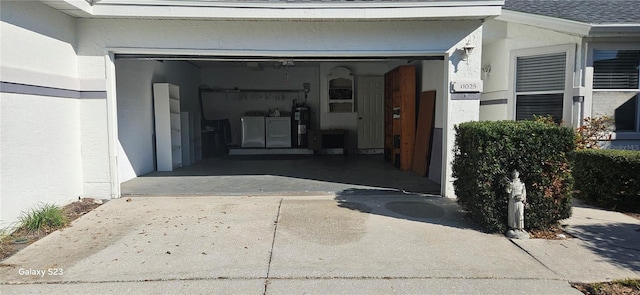 garage with washer and dryer and concrete driveway