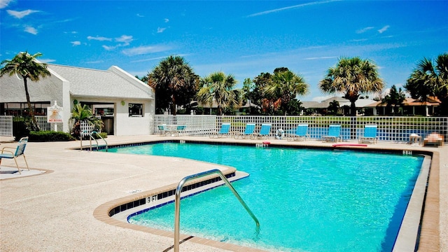 community pool featuring fence and a patio