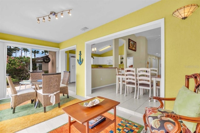 living room featuring tile patterned floors, visible vents, and lofted ceiling