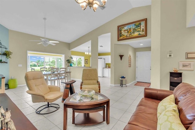 living room featuring light tile patterned floors, ceiling fan with notable chandelier, high vaulted ceiling, and baseboards