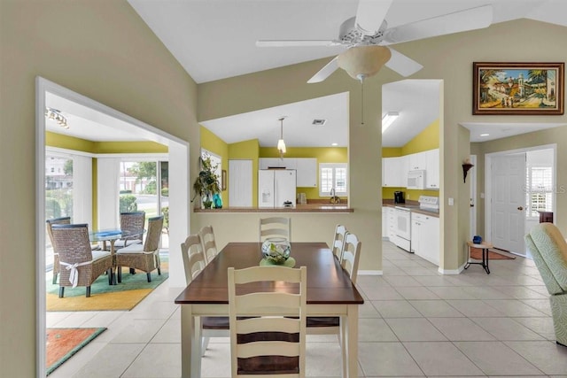 dining area featuring light tile patterned floors, lofted ceiling, a healthy amount of sunlight, and ceiling fan