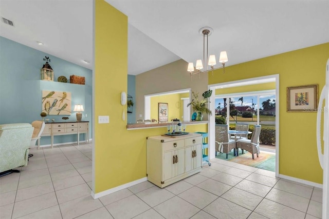 kitchen featuring an inviting chandelier, light tile patterned floors, baseboards, and pendant lighting