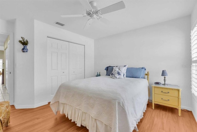 bedroom featuring light wood finished floors, baseboards, visible vents, and a closet