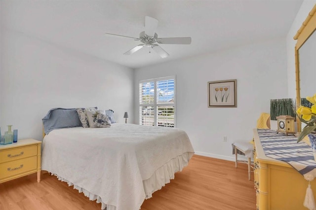 bedroom with light wood finished floors, baseboards, and ceiling fan