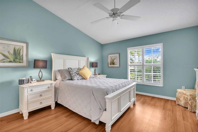 bedroom featuring baseboards, lofted ceiling, light wood-style floors, and ceiling fan