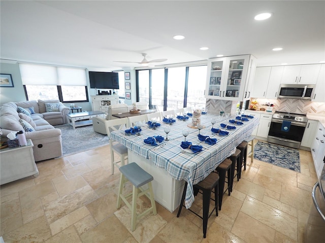 dining room featuring plenty of natural light, stone tile floors, and recessed lighting