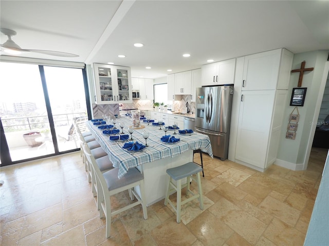 kitchen with tile countertops, recessed lighting, stone tile floors, stainless steel appliances, and white cabinetry