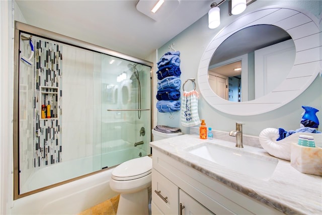 bathroom with bath / shower combo with glass door, vanity, toilet, and tile patterned floors