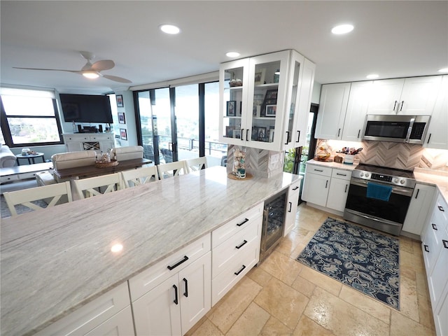 kitchen featuring beverage cooler, appliances with stainless steel finishes, recessed lighting, and decorative backsplash