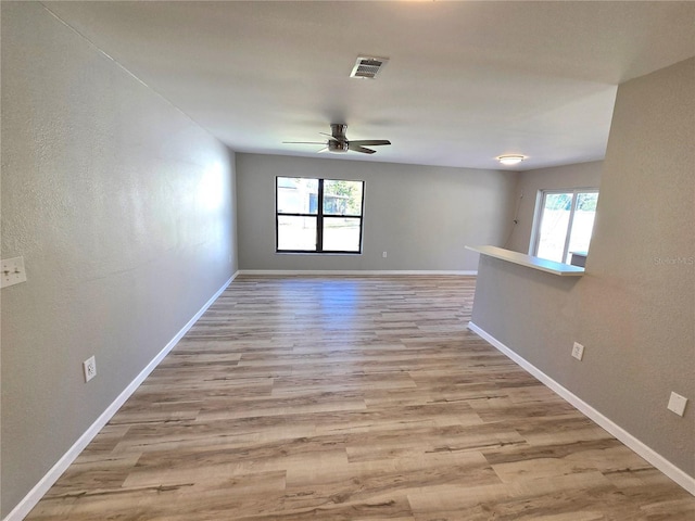 unfurnished room with a healthy amount of sunlight, visible vents, and light wood-style flooring