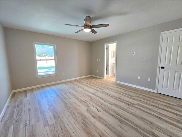 unfurnished room with light wood finished floors, a ceiling fan, and baseboards