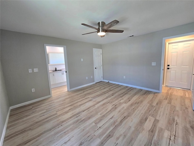 spare room featuring light wood-style floors, visible vents, ceiling fan, and baseboards