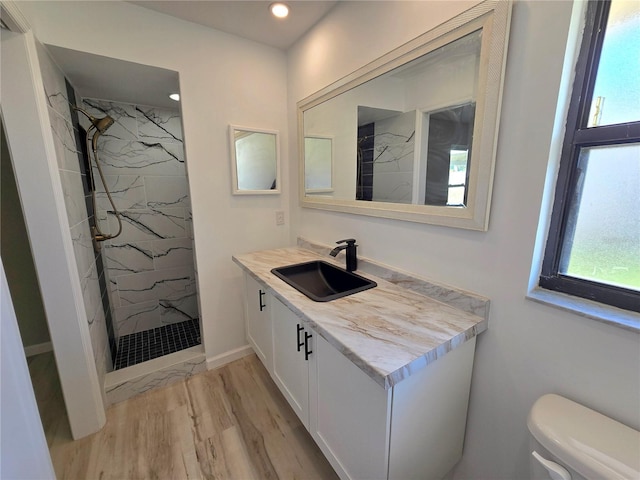 full bathroom with toilet, recessed lighting, wood finished floors, vanity, and a marble finish shower