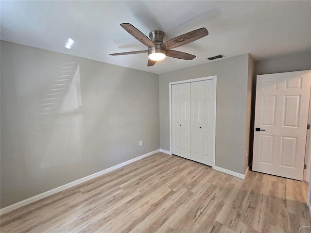 unfurnished bedroom featuring a closet, visible vents, light wood-style floors, a ceiling fan, and baseboards