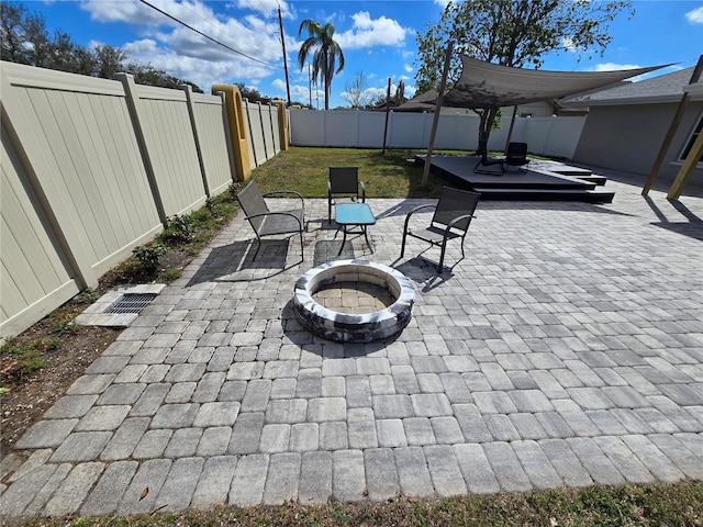 view of patio with a fenced backyard and a fire pit