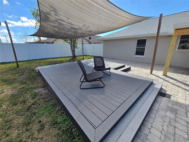 deck with a patio area and a fenced backyard