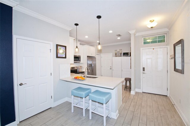 5118 78th St Cir E, Bradenton, FL 34203 - kitchen featuring a peninsula, wood finish floors, white cabinetry, light countertops, and appliances with stainless steel finishes