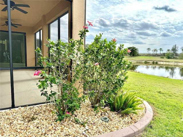 exterior space with a ceiling fan and a water view