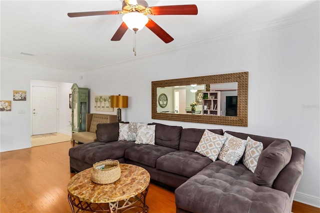 living area with crown molding, baseboards, ceiling fan, and wood finished floors