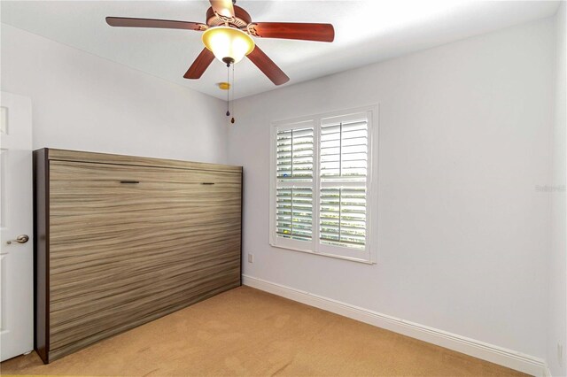 spare room featuring baseboards and light colored carpet