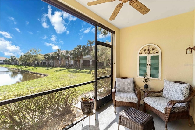 sunroom / solarium featuring a ceiling fan, a water view, and plenty of natural light