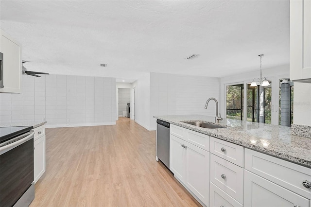 kitchen featuring decorative light fixtures, visible vents, appliances with stainless steel finishes, white cabinets, and a sink