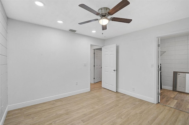 unfurnished bedroom with a walk in closet, recessed lighting, visible vents, light wood-type flooring, and baseboards