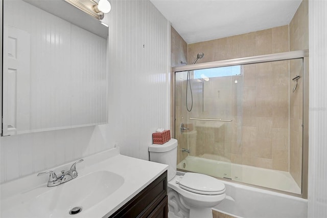 full bath with toilet, bath / shower combo with glass door, and vanity