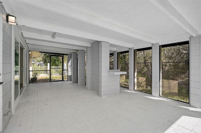 unfurnished sunroom with beam ceiling