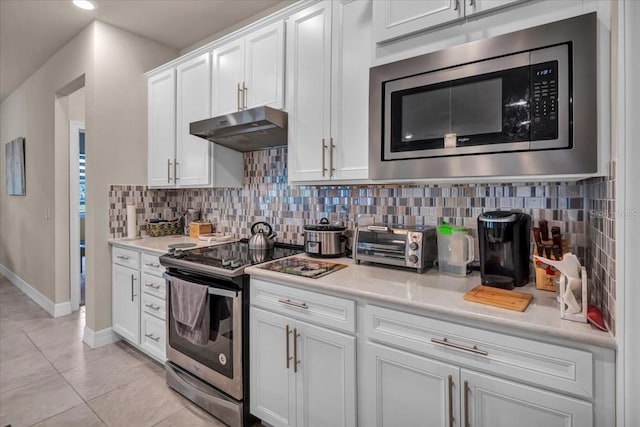 kitchen with light countertops, appliances with stainless steel finishes, white cabinetry, and under cabinet range hood