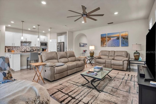 living area featuring light tile patterned flooring, visible vents, a ceiling fan, and recessed lighting