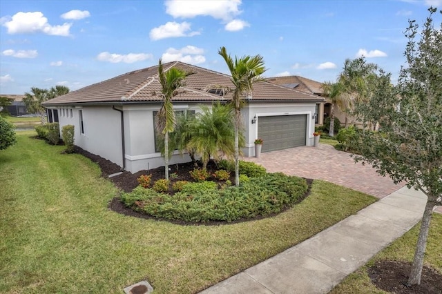 ranch-style home featuring decorative driveway, stucco siding, an attached garage, a front yard, and a tiled roof